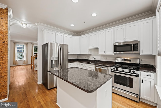 kitchen featuring a center island, white cabinetry, appliances with stainless steel finishes, and light hardwood / wood-style flooring