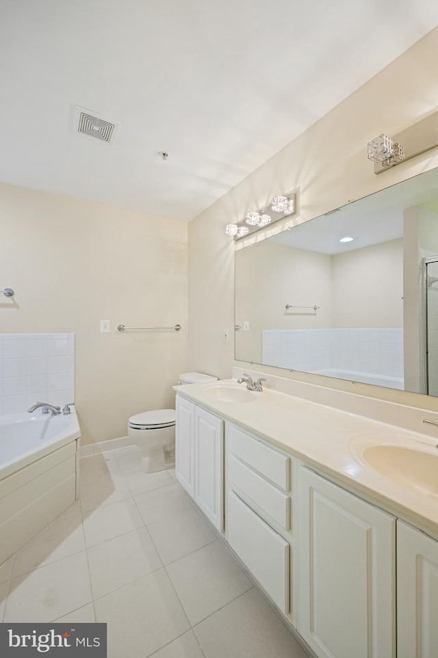 bathroom featuring tile patterned flooring, vanity, toilet, and a washtub