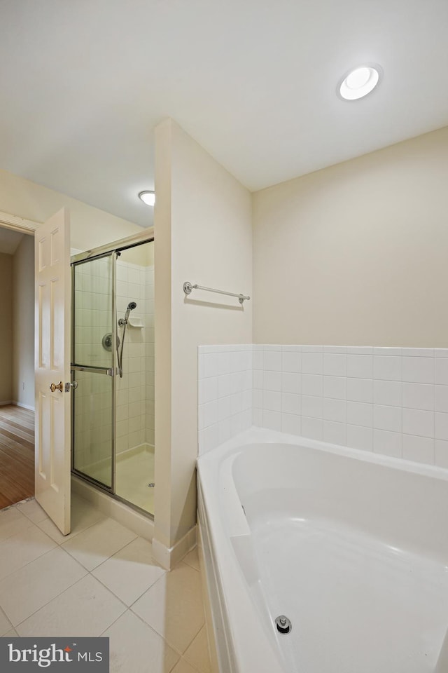 bathroom with tile patterned flooring and separate shower and tub