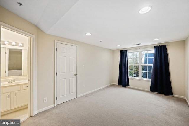 spare room featuring light carpet and sink