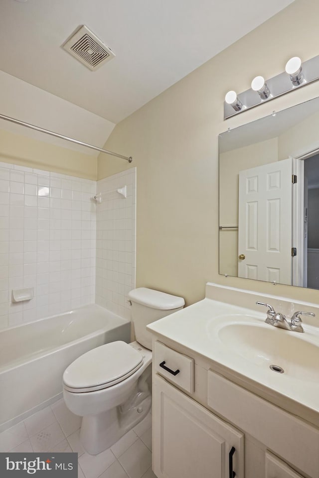 full bathroom featuring vanity, tile patterned floors, tiled shower / bath, vaulted ceiling, and toilet