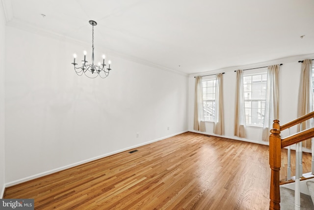 unfurnished room with wood-type flooring, crown molding, and a chandelier