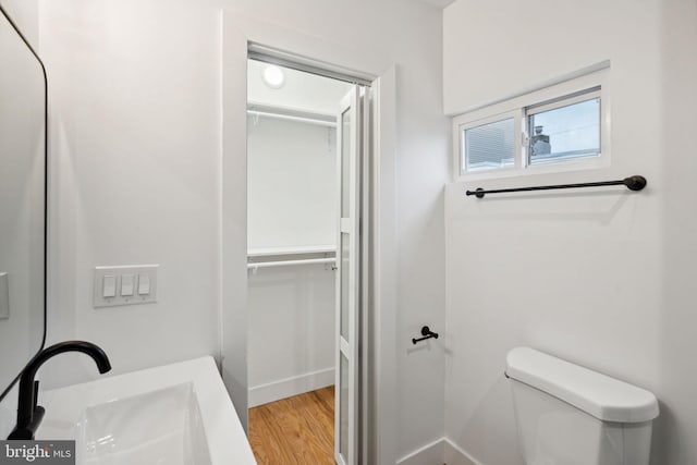 bathroom featuring toilet, sink, and hardwood / wood-style floors