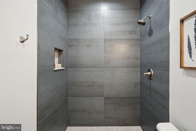 bathroom with toilet and tiled shower