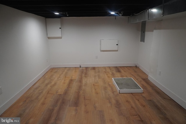 basement with hardwood / wood-style floors and electric panel