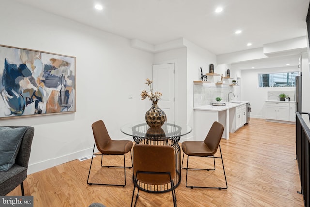 dining space featuring light hardwood / wood-style floors and sink