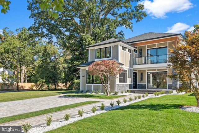 view of front of property with a front yard and a balcony