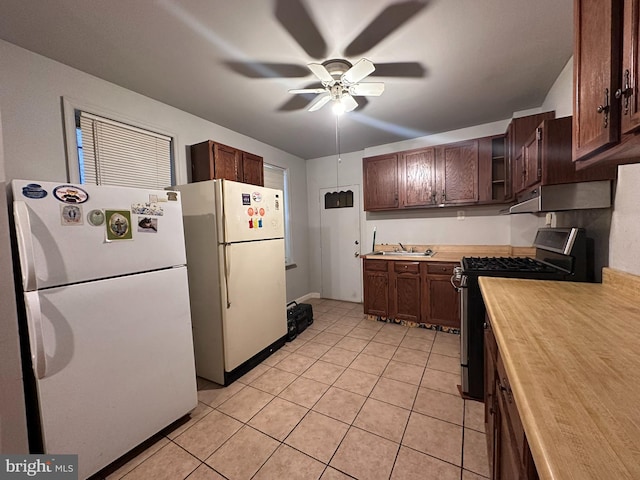 kitchen featuring sink, white fridge, gas stove, and ceiling fan