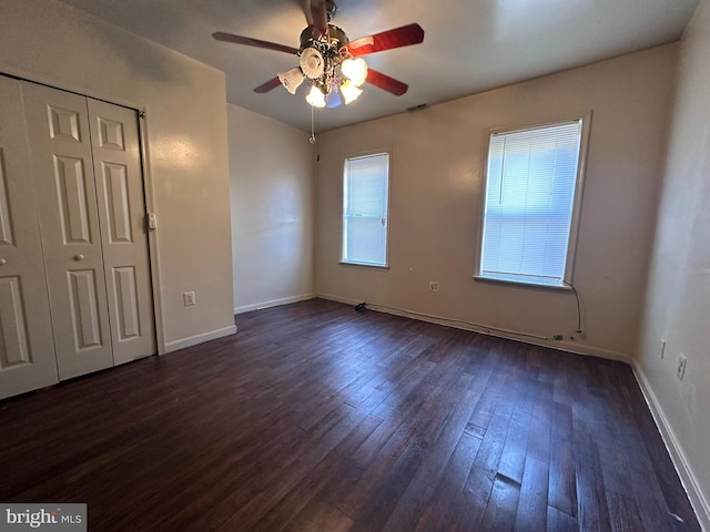 unfurnished bedroom featuring a closet, dark wood-type flooring, and ceiling fan