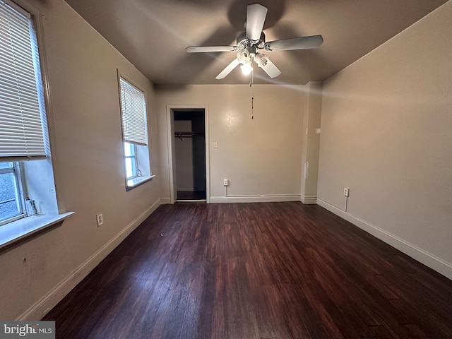 empty room with ceiling fan and dark hardwood / wood-style flooring