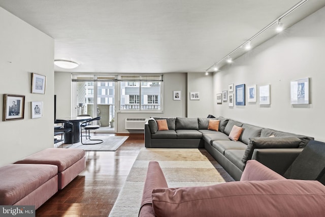 living room featuring a wall mounted AC, track lighting, and hardwood / wood-style flooring