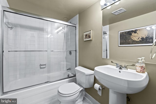 bathroom featuring enclosed tub / shower combo, tile patterned floors, and toilet