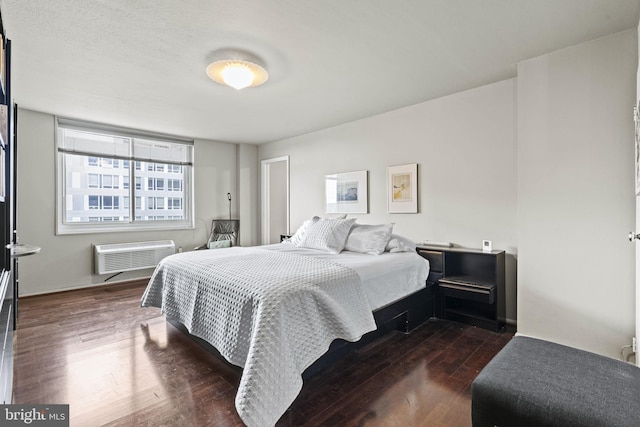 bedroom with dark wood-type flooring and a wall mounted air conditioner