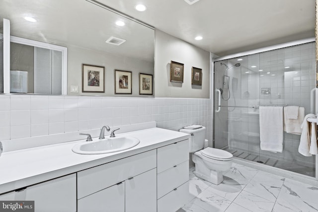 bathroom with tile walls, walk in shower, vanity, and toilet