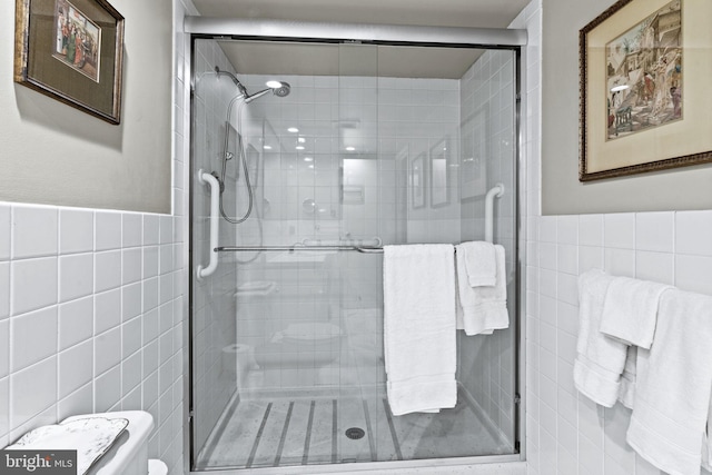 bathroom with tile walls and a shower with door