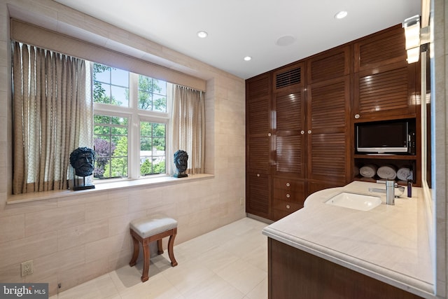 bathroom with tile walls and sink