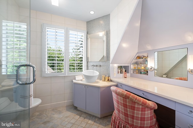 bathroom featuring a shower with shower door, toilet, tile patterned floors, tile walls, and vanity