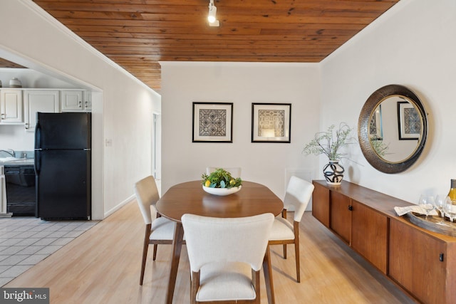 dining area featuring wood ceiling, crown molding, sink, and light hardwood / wood-style flooring