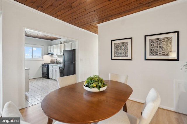 dining space with crown molding, wooden ceiling, and light hardwood / wood-style flooring