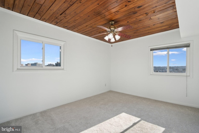 unfurnished room with crown molding, ceiling fan, carpet, and wooden ceiling