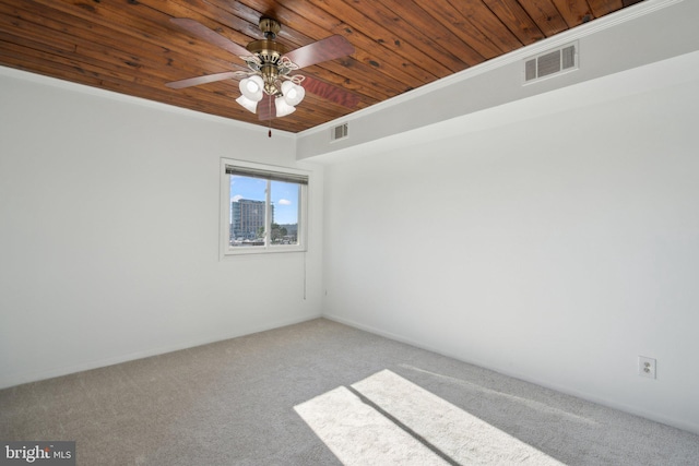 carpeted spare room with ceiling fan, ornamental molding, and wooden ceiling