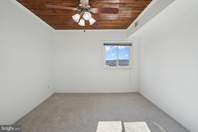 carpeted empty room featuring wood ceiling, ornamental molding, and ceiling fan