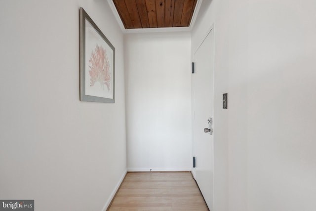 corridor featuring ornamental molding, wooden ceiling, and light hardwood / wood-style floors