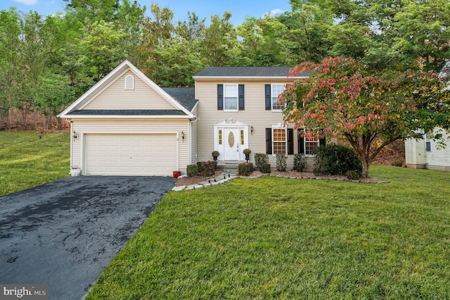 colonial house featuring a front lawn and a garage