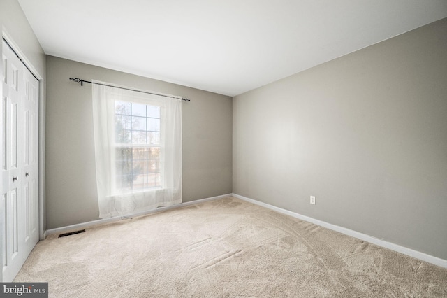 spare room featuring light carpet