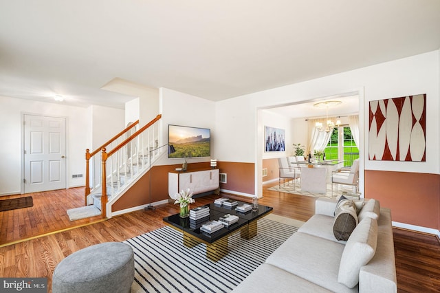 living room featuring hardwood / wood-style flooring and an inviting chandelier