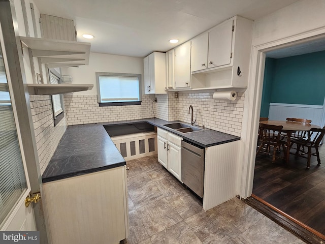 kitchen featuring hardwood / wood-style flooring, sink, stainless steel dishwasher, white cabinets, and tasteful backsplash