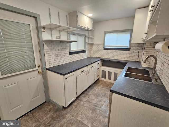 kitchen with decorative backsplash, sink, and white cabinets