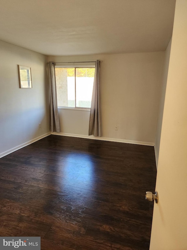 spare room with dark hardwood / wood-style floors