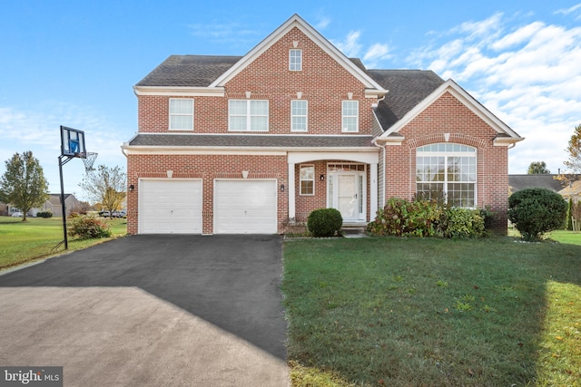 view of property featuring a garage and a front lawn