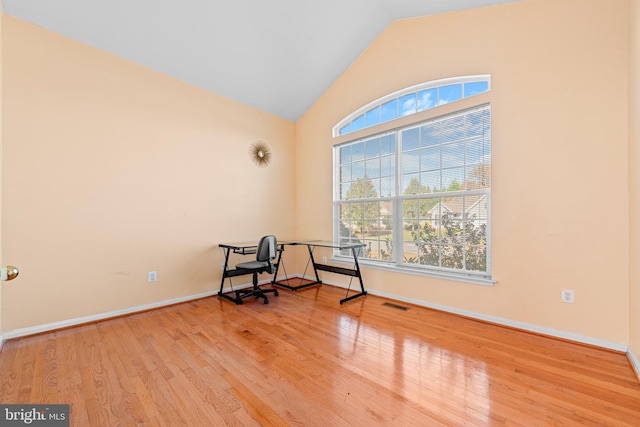 living area featuring hardwood / wood-style floors, vaulted ceiling, and plenty of natural light