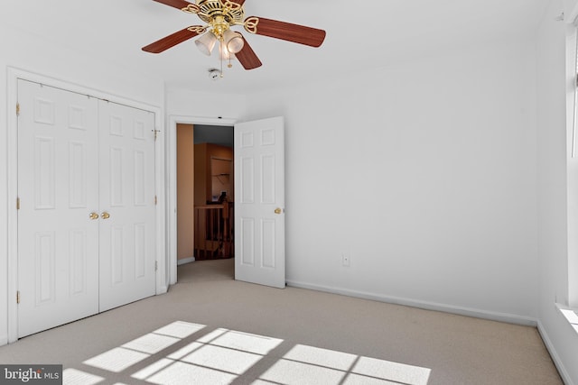 unfurnished bedroom featuring light colored carpet, a closet, and ceiling fan