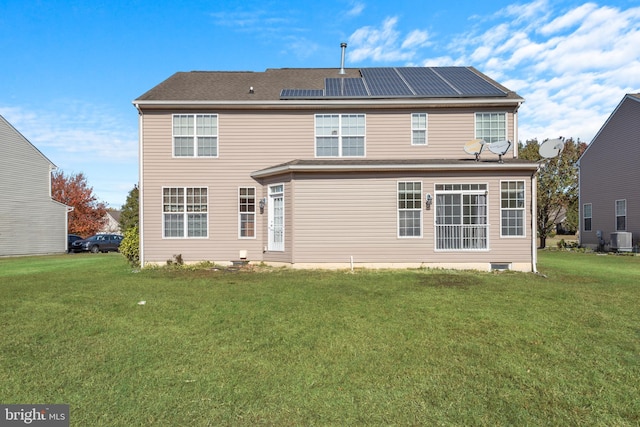 rear view of house with central AC unit and a lawn