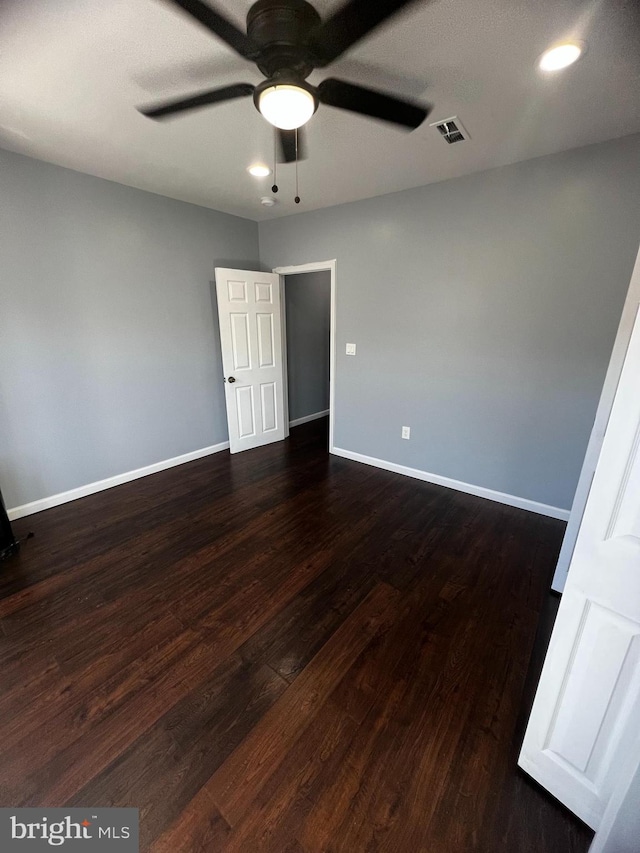 unfurnished room with ceiling fan and dark hardwood / wood-style flooring