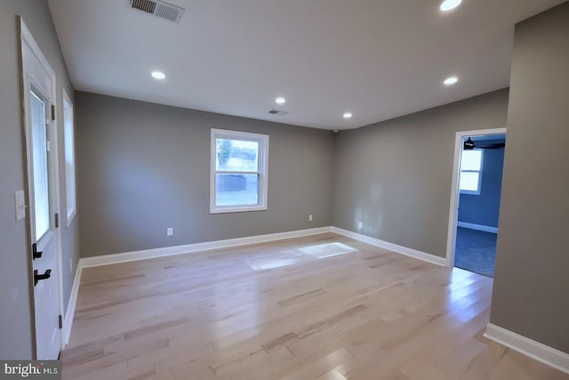 unfurnished room featuring light hardwood / wood-style floors and lofted ceiling