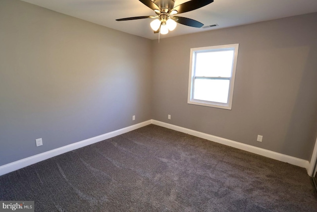 empty room with ceiling fan and dark carpet