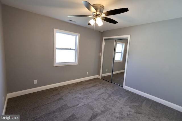 unfurnished bedroom featuring multiple windows, a closet, carpet, and ceiling fan