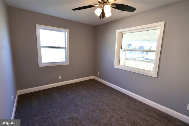 carpeted empty room with ceiling fan and a wealth of natural light