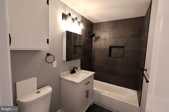 full bathroom with vanity, tiled shower / bath combo, and toilet