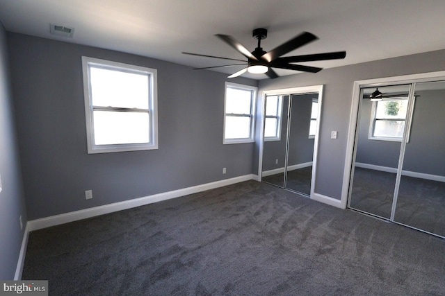 unfurnished bedroom with dark colored carpet and ceiling fan