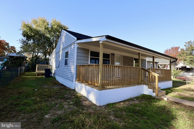 view of front facade featuring a front yard and central air condition unit