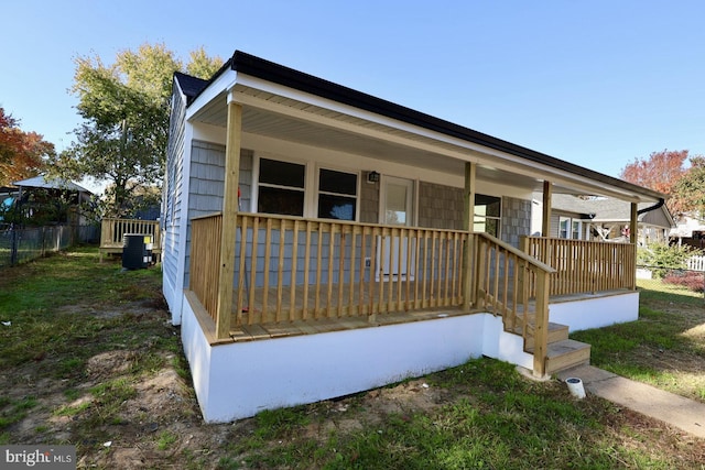 view of front of property featuring a porch and cooling unit