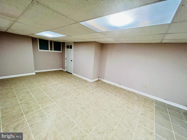 basement with tile patterned floors and a paneled ceiling