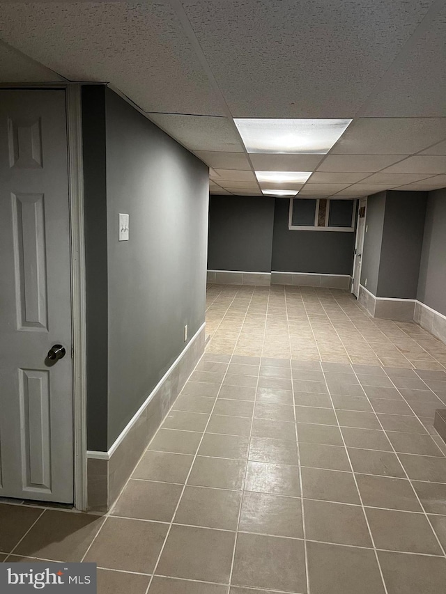 interior space featuring a paneled ceiling and tile patterned floors