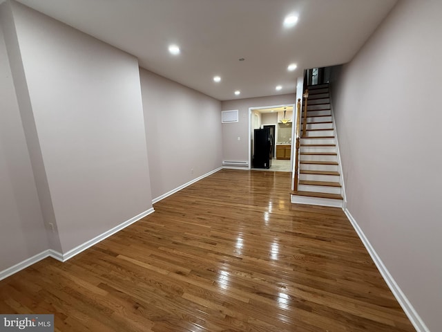 interior space with a baseboard heating unit and wood-type flooring