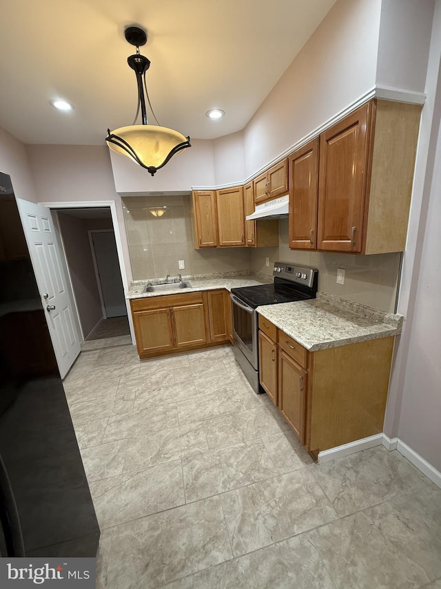 kitchen featuring light stone counters, sink, hanging light fixtures, and stainless steel electric range oven